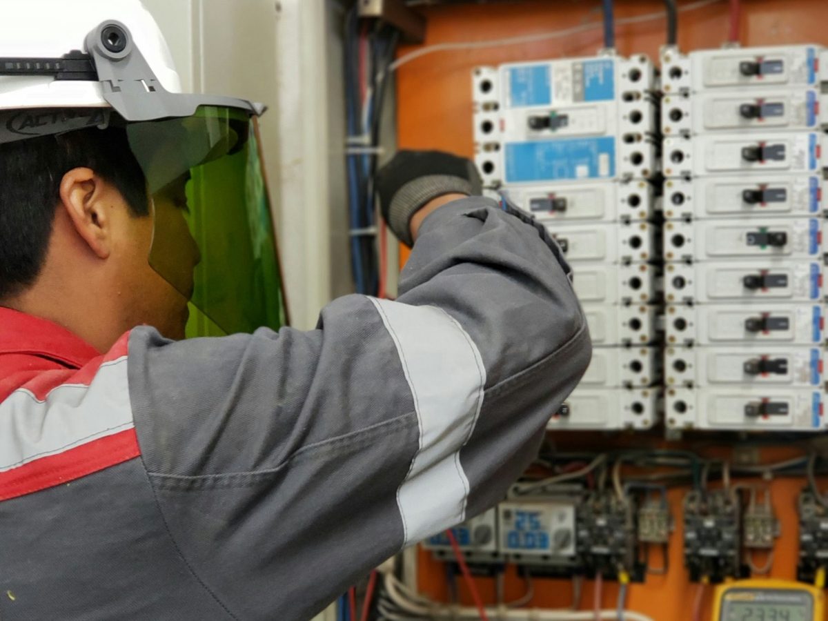 An electrician metering a breaker panel