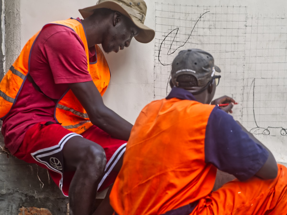 Two contractors in hi-vis reviewing plans on site