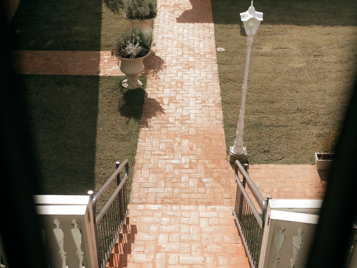 A brick pathway running through a planted garden