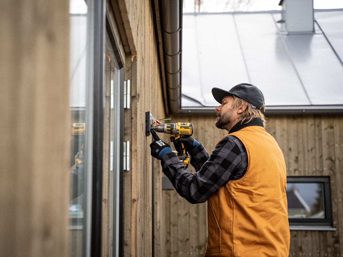 A fitter drilling a new window into place
